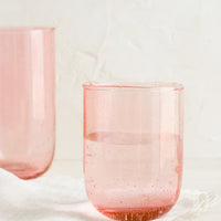 Rose / 8 oz: Short and tall glass tumblers in seeded pink glass.