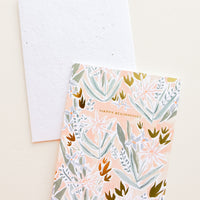 1: Greeting card in peach color with floral print and "Happy Beginnings" text