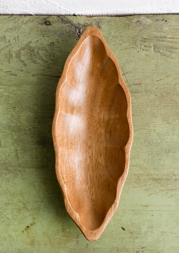 An elongated diamond or "seed pod" shaped wooden dish.