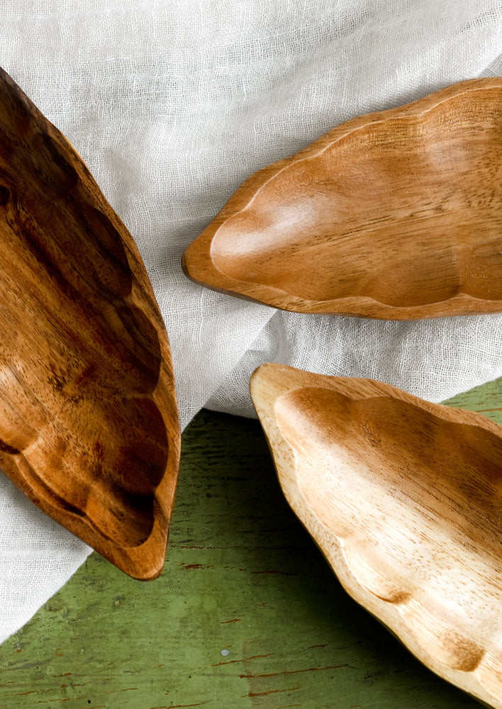 3: Seedpod shaped dishes in slightly varying shades of wood tone.