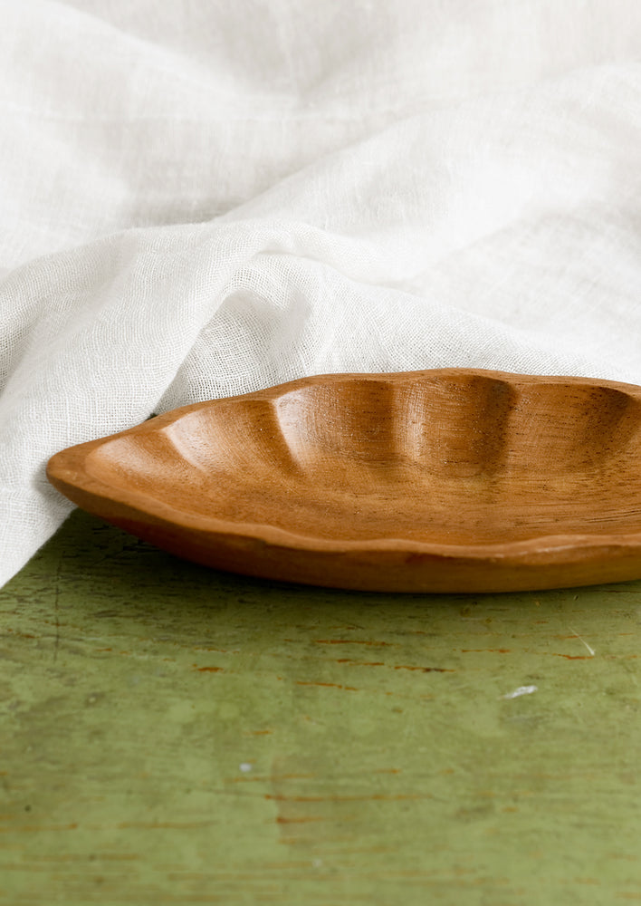 4: An elongated diamond or "seed pod" shaped wooden dish.