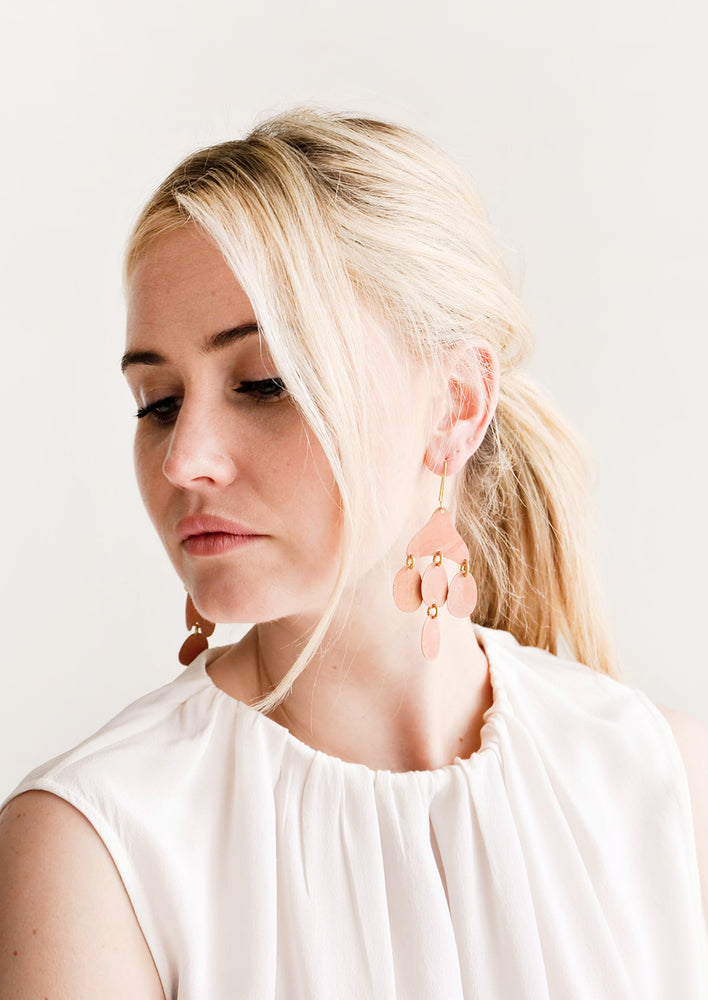 Model shot showing woman wearing earrings and a white top.