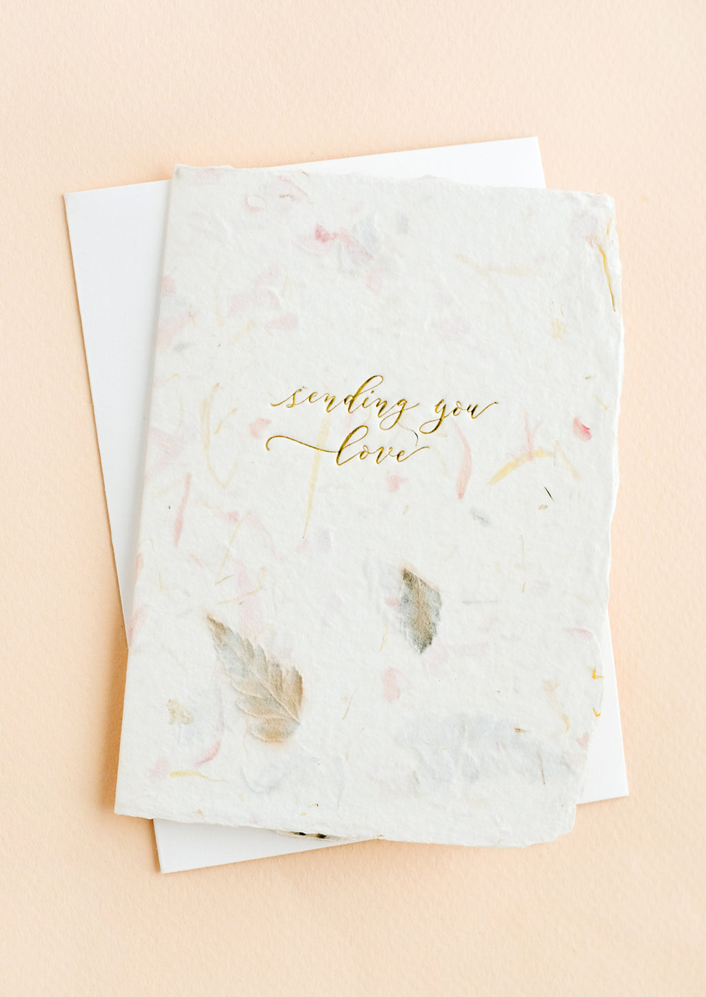 3: A greeting card made from handmade flower paper with gold script on front that reads "Sending You Love".