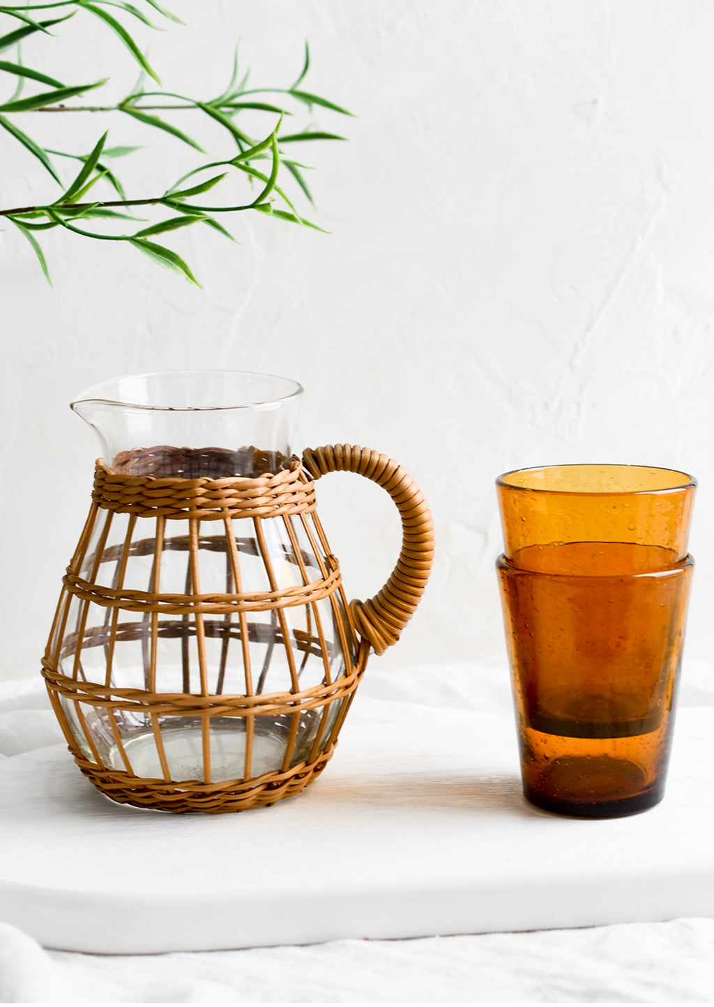 2: A seagrass wrapped pitcher and amber glass cups.