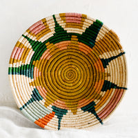 1: A woven raffia bowl with sunburst pattern.