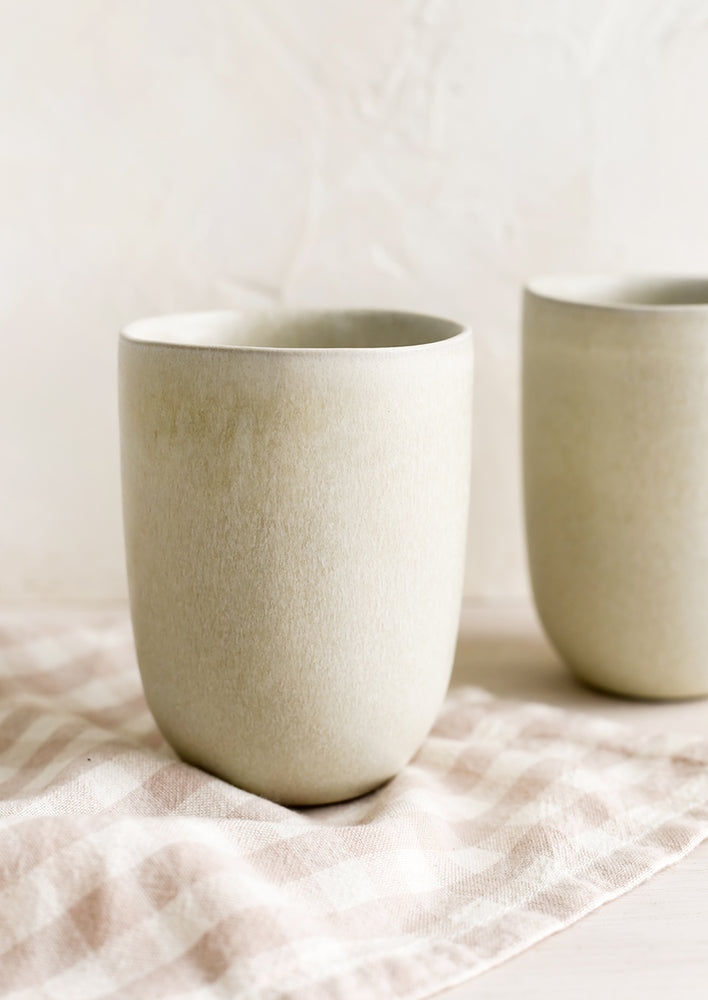 1: A smooth ceramic cup in neutral beige matte glaze.