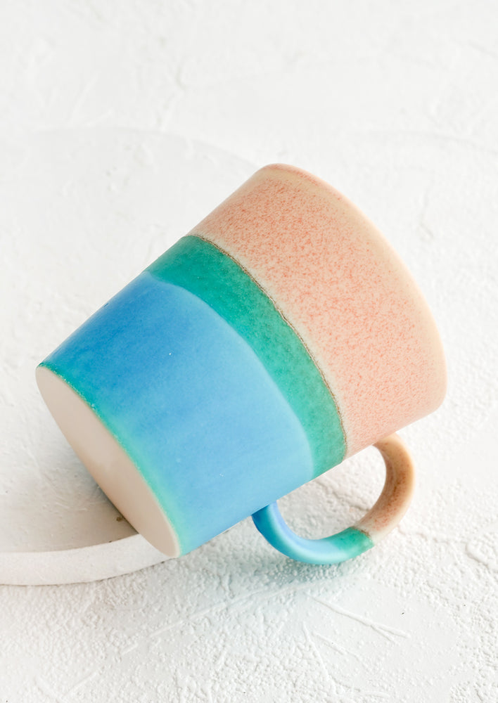 Pink / Turquoise: A ceramic coffee mug with handle in tri color pink and blue glaze.
