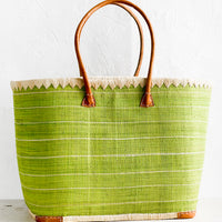 1: A raffia tote bag in green stripes with leather handles.