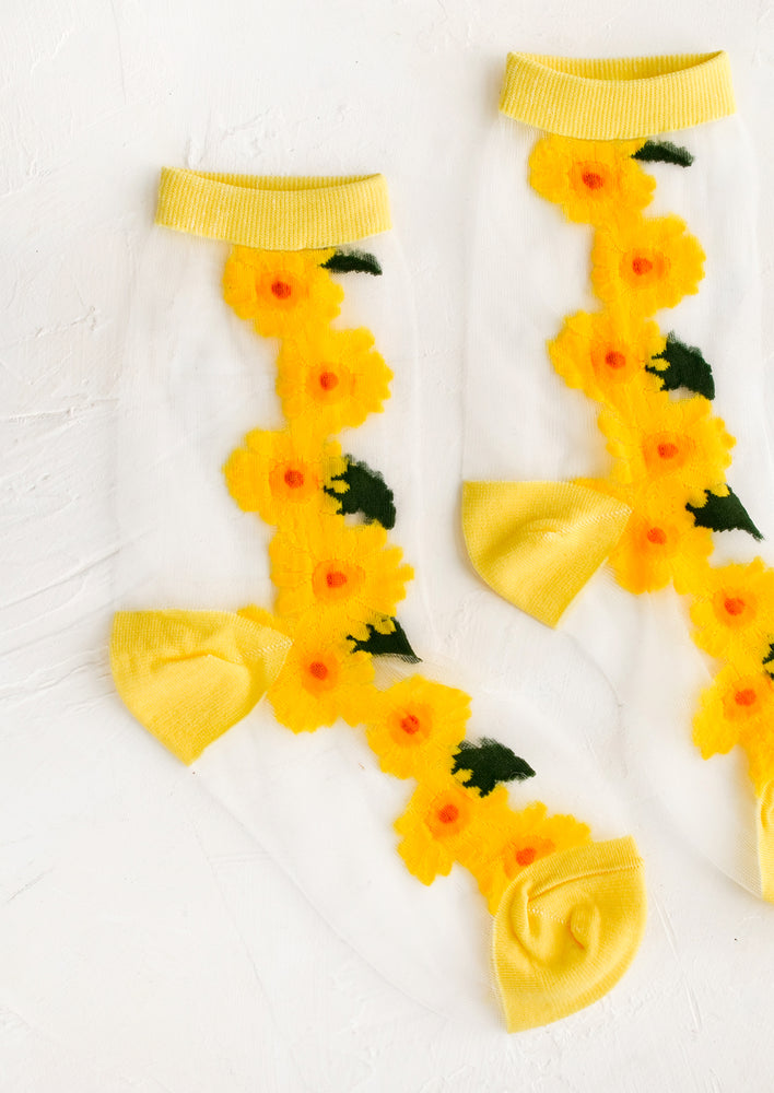 Sheer nylon sock with sunflower design and yellow trim.