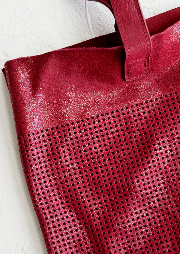 Perforation detailing on leather tote bag.