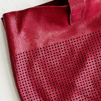 3: Perforation detailing on leather tote bag.