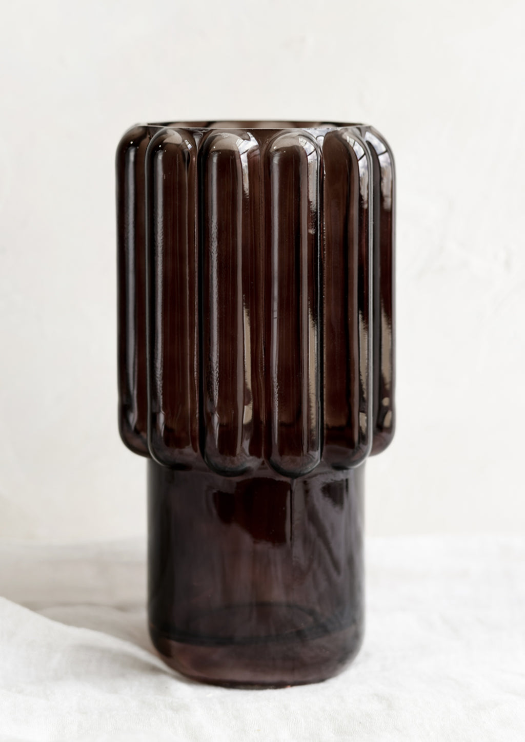 1: A large glass vase in dark brown with fluted texture.