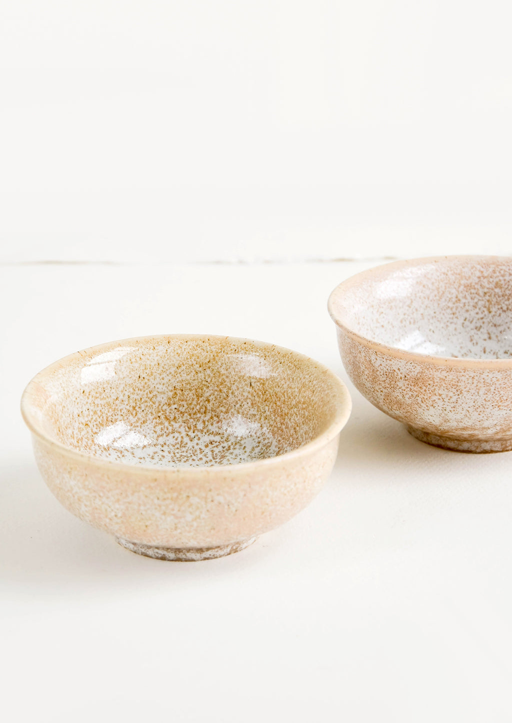 1: Small ceramic bowls with footed silhouette in reactive brown glaze