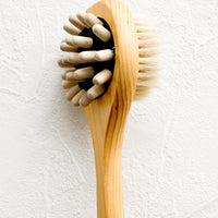 2: A two-sided wooden shower brush with wooden massager pegs on one side and boar bristle on the other.
