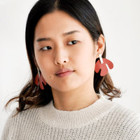 2: Model shot wearing earrings and a white sweater.