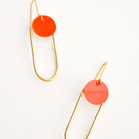 Red Coral: Pair of earrings in the shape of a hollow brass oval with a red dot at the top. 