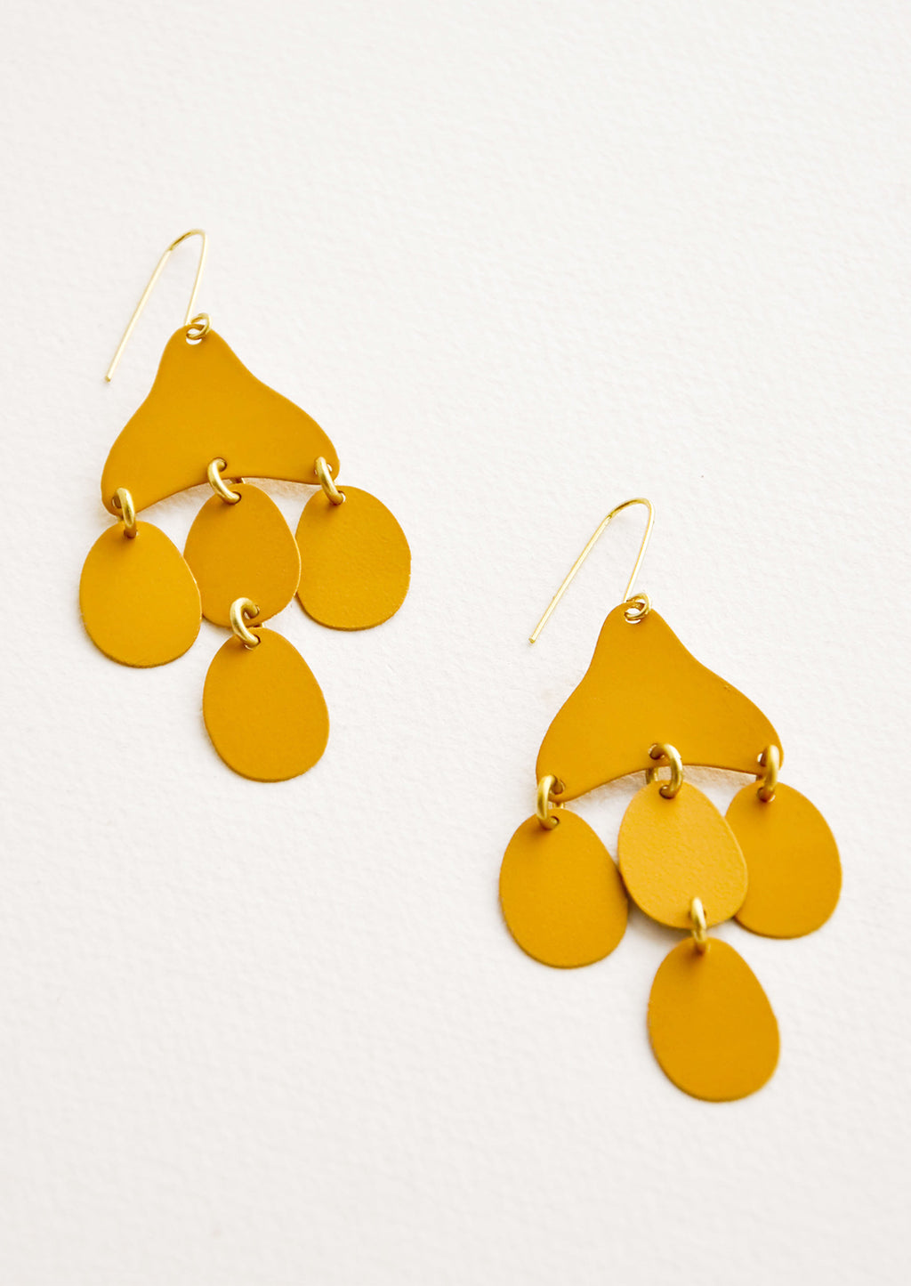 Saffron: Dangling earrings featuring 4 oval shape charms in matte dark yellow metal hanging from an asymmetric triangle in the same color.