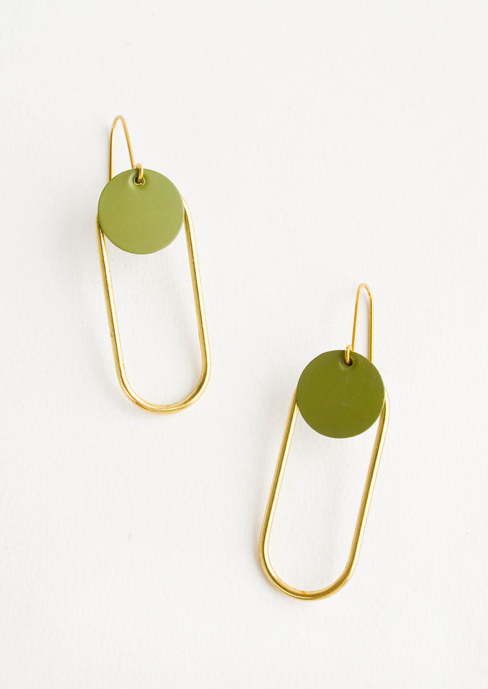 Pair of earrings in the shape of a hollow brass oval with a green dot at the top.