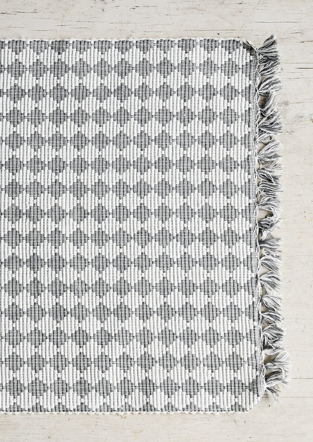 2: A table runner in ribbed textured grey and white checker print.