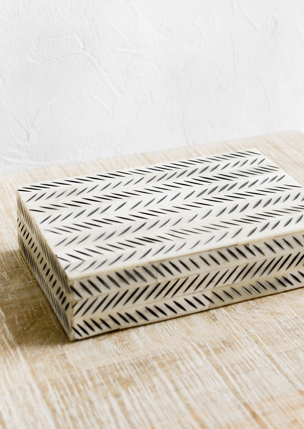 1: A decorative storage box made from ivory bone with black etched "slash" pattern.