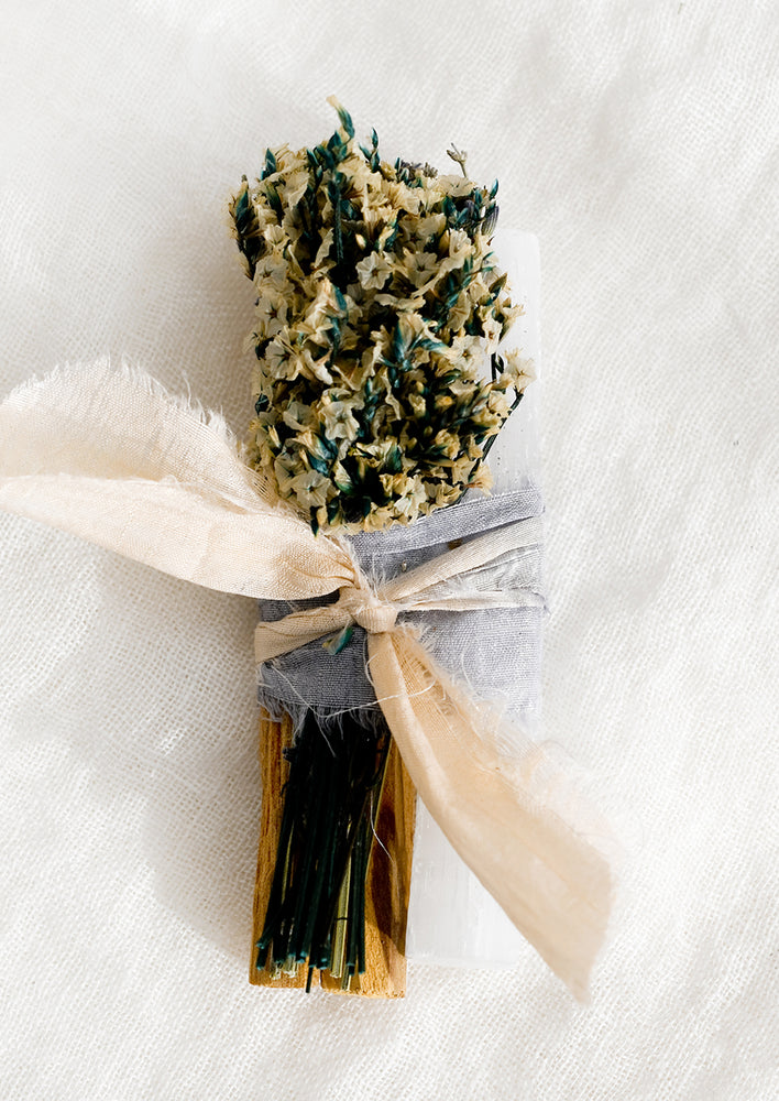 1: A silk ribbon bound bundle of palo santo, dried flowers and selenite.