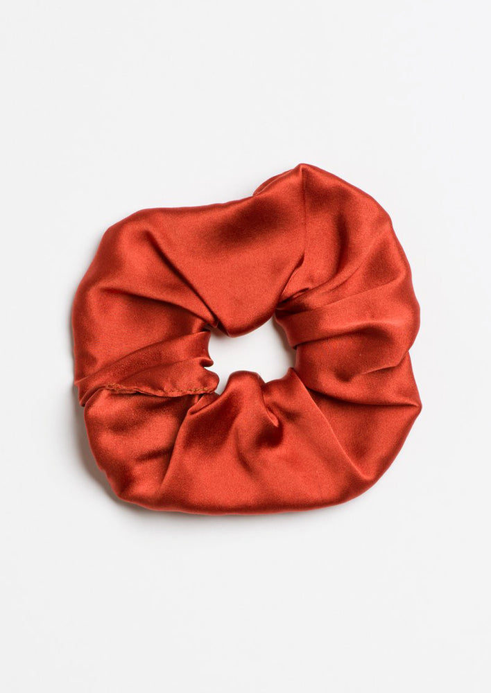 A silk scrunchie in brick red.