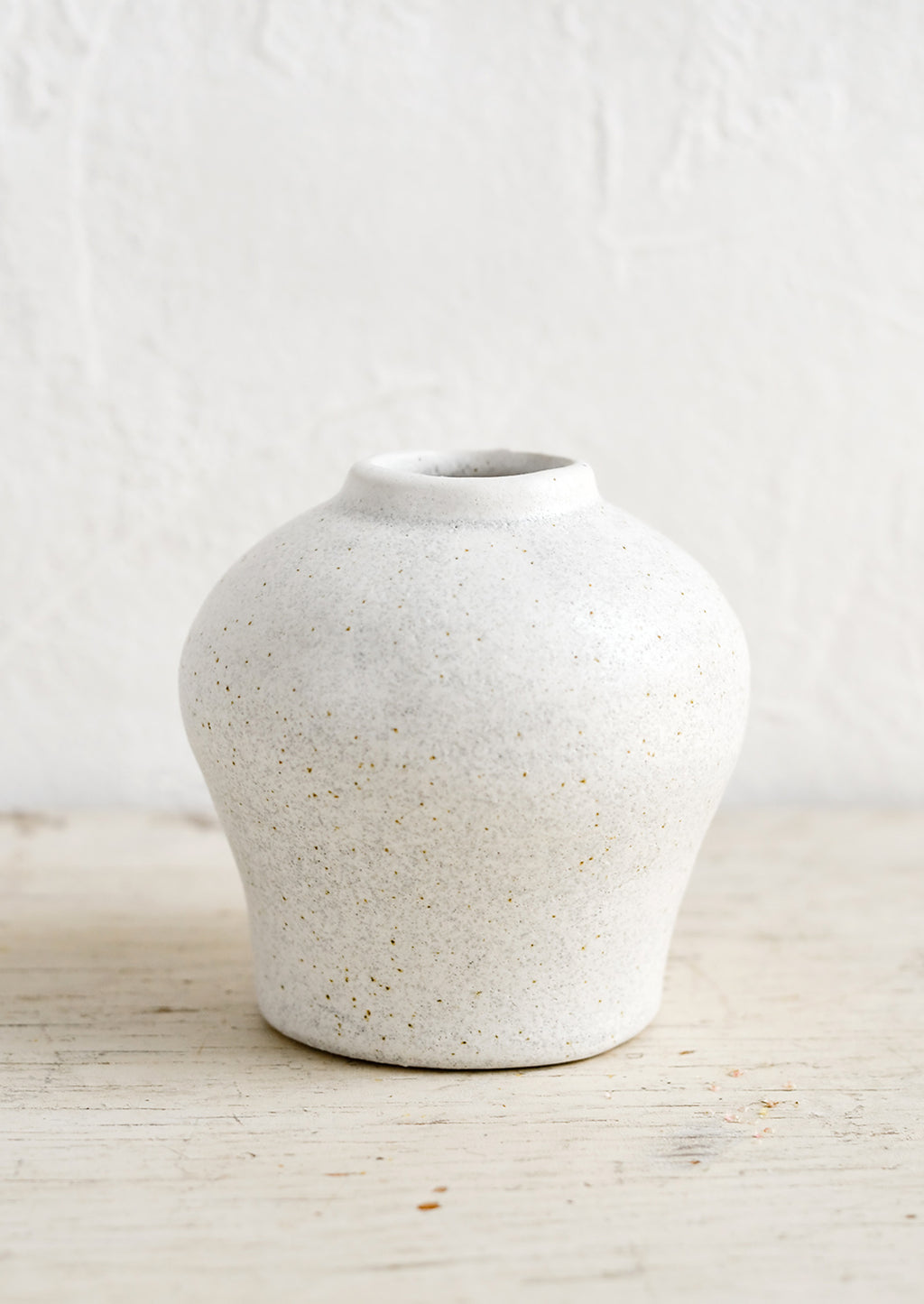 1: A small white ceramic vase in an urn-like shape.