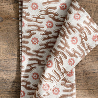 1: A natural cotton napkin with brown and peach abstract flower print.
