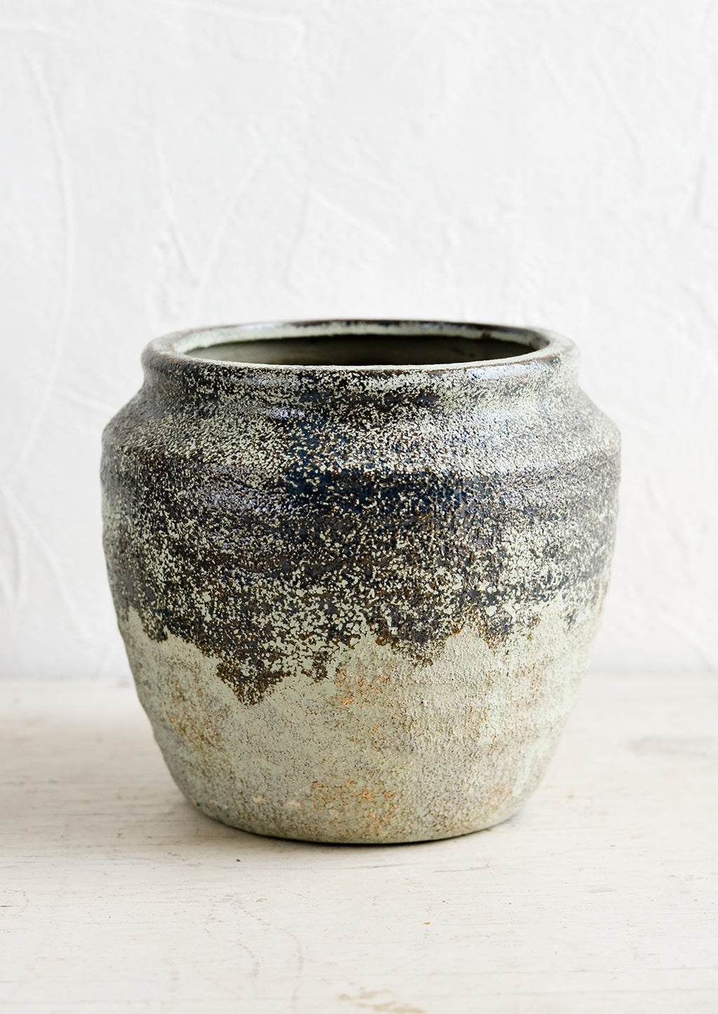 1: A ceramic planter in a distressed mossy green patina.