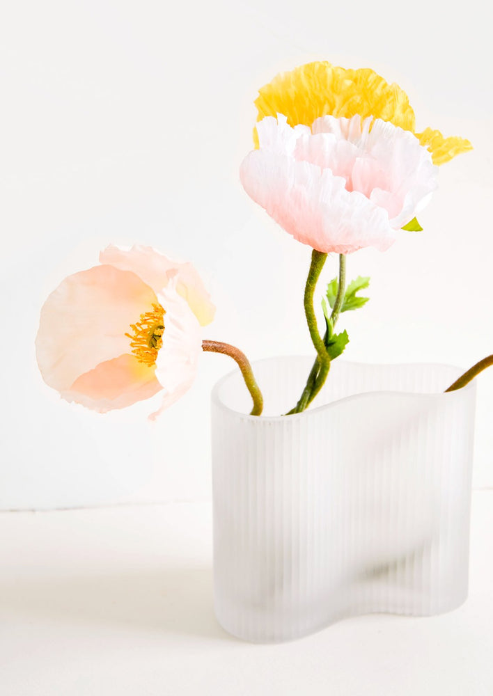 Frosted glass vase in asymmetric shape, housing multicolor poppies