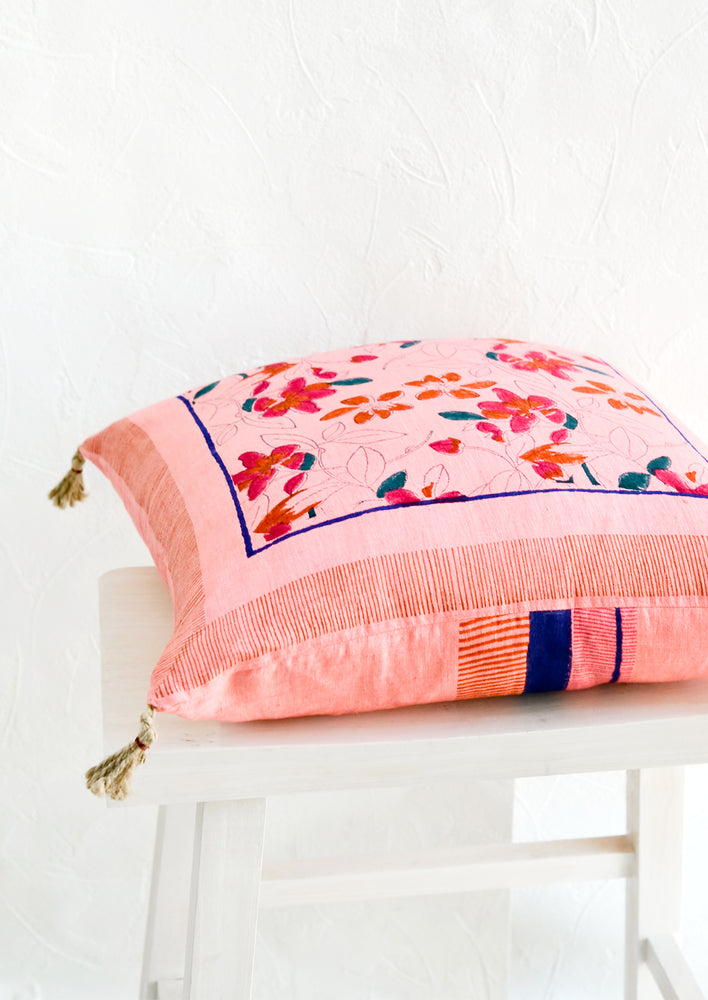 2: A throw pillow on its side, showing contrasting prints on front and back.