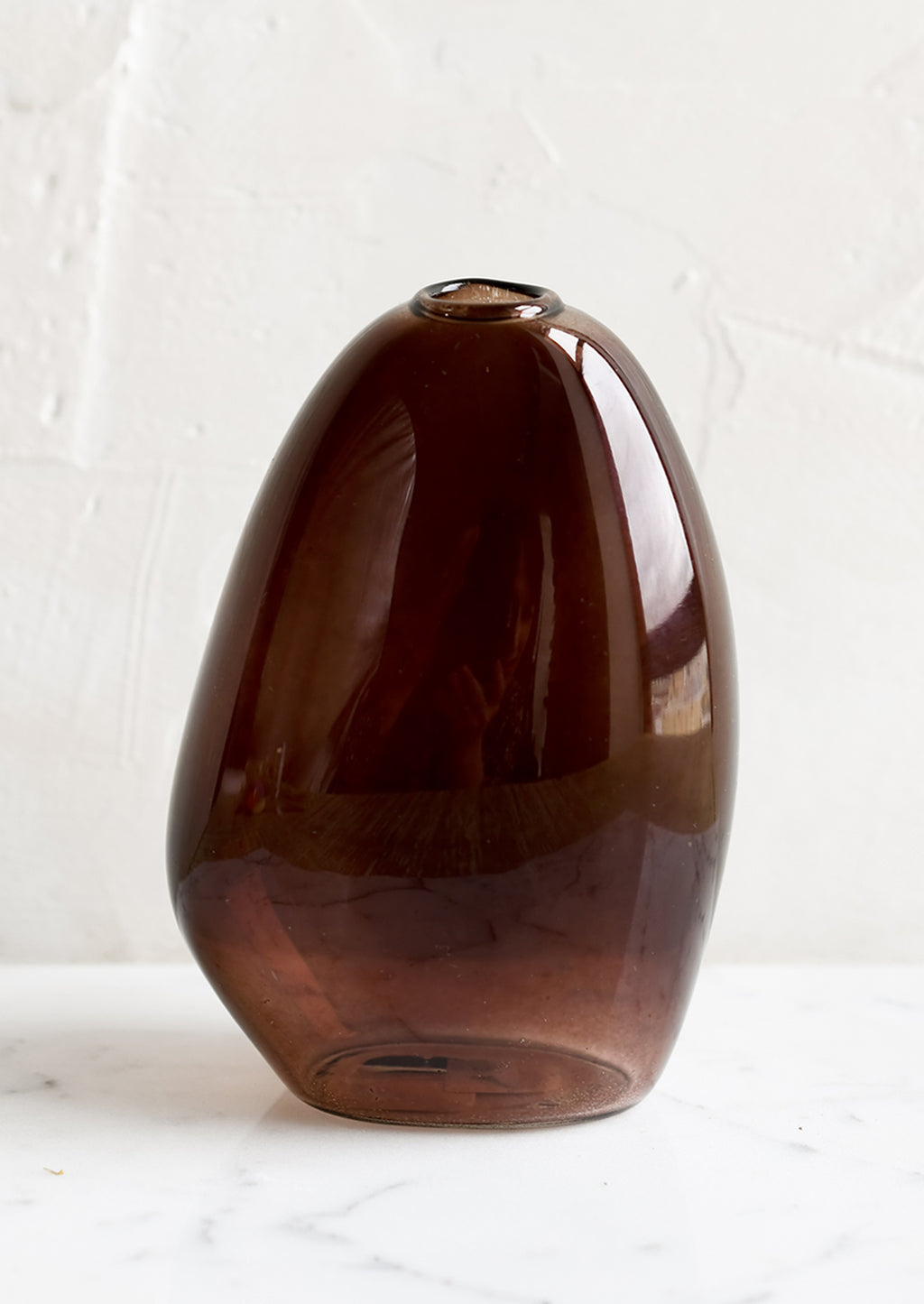 1: An asymmetrical bud vase in brown colored glass.
