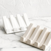 Cream: Slanted soap dishes made from white and beige concrete.