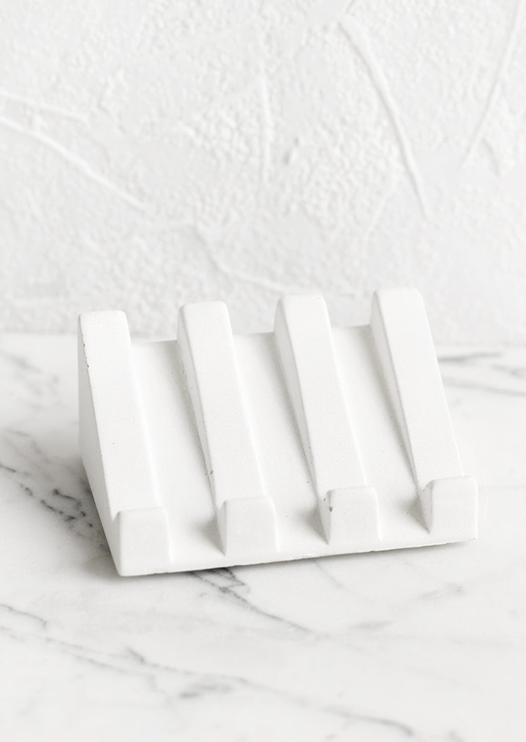 White: A slanted soap dish made in white concrete.