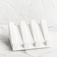 White: A slanted soap dish made in white concrete.