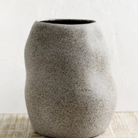 Tall: An asymmetrical shaped ceramic planter in matte, speckled grey glaze.