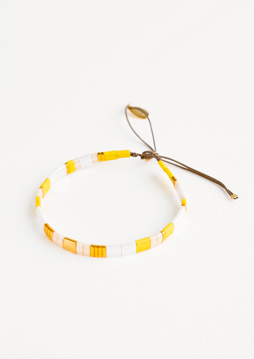 Yellow: Bracelet featuring flat yellow and white glass beads interspersed with flat gold bead on an adjustable cord.