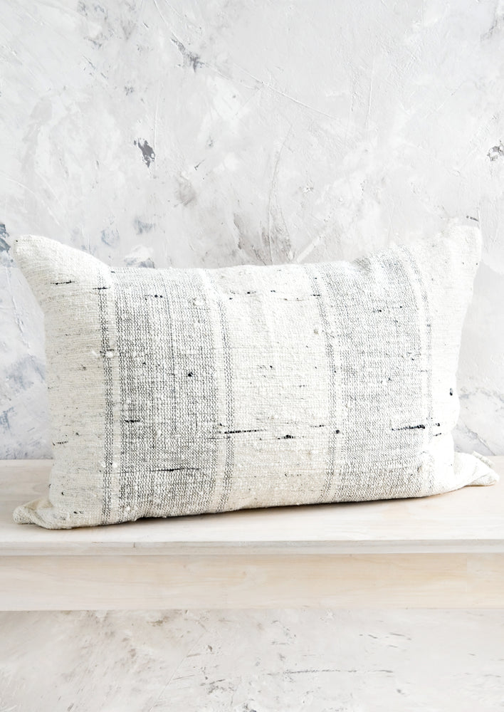 Lumbar throw pillow in textured cotton slub fabric with light grey vertical stripes.