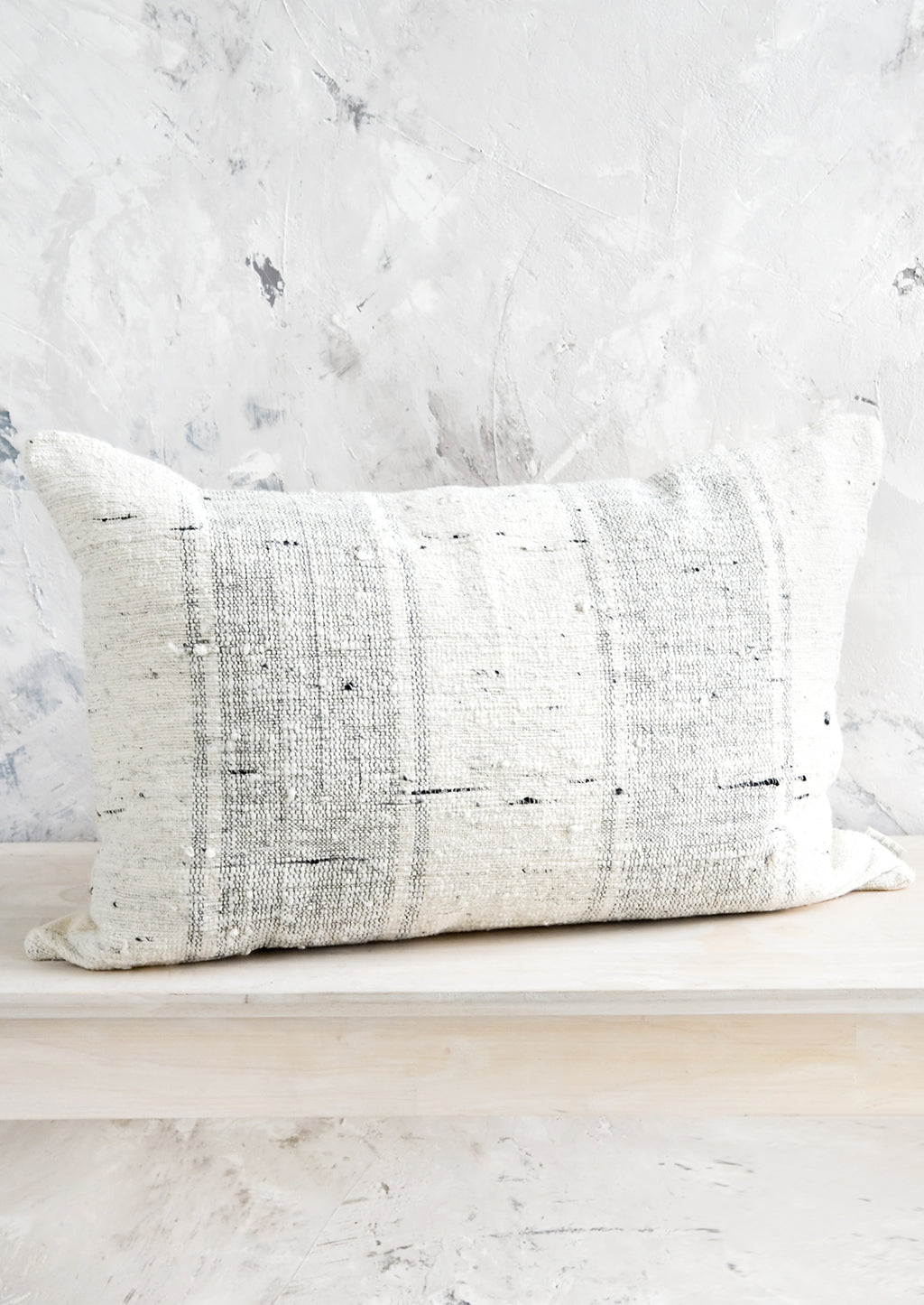 4: Lumbar throw pillow in textured cotton slub fabric with light grey vertical stripes.