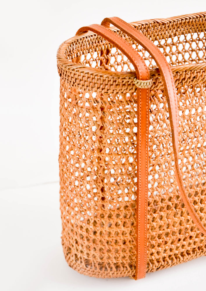 Shoulder tote bag with thin leather straps, made from open-weave rattan with a tanned effect