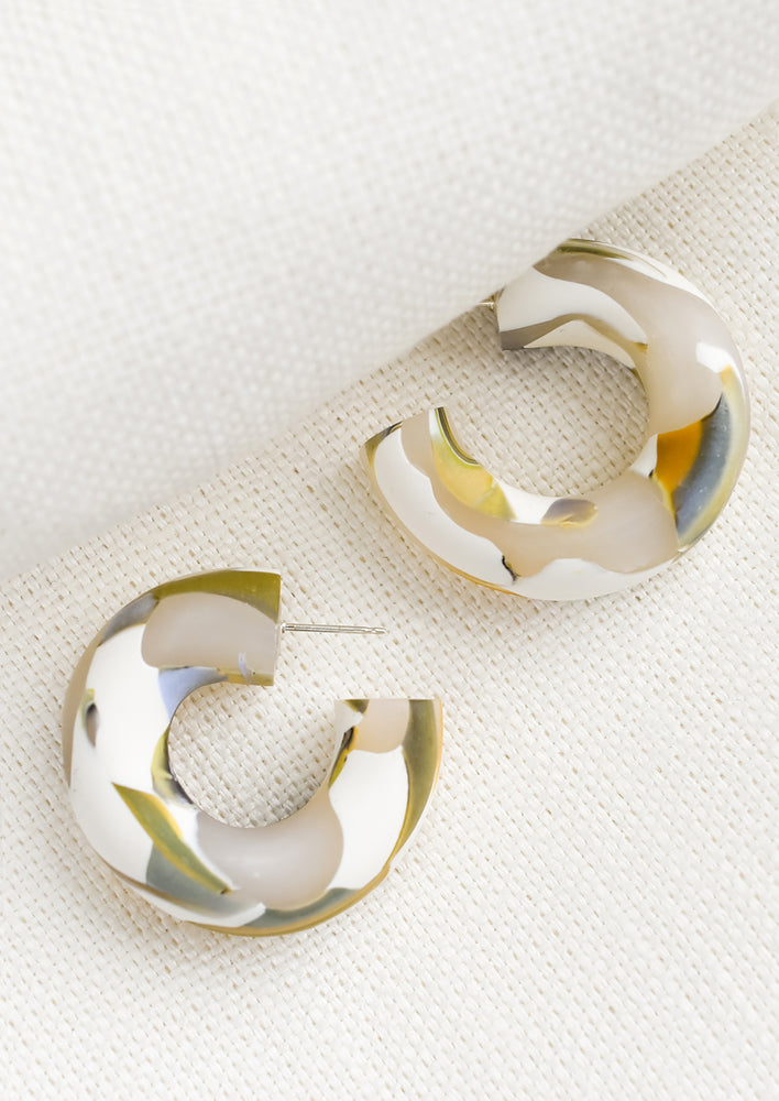 1: A pair of clay hoop earrings in translucent marbled design.