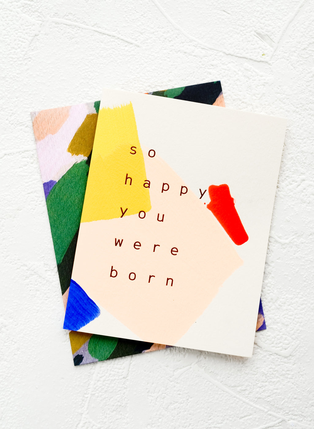 2: A greeting card with hand-painted geometric shapes and text reading "So happy you were born"