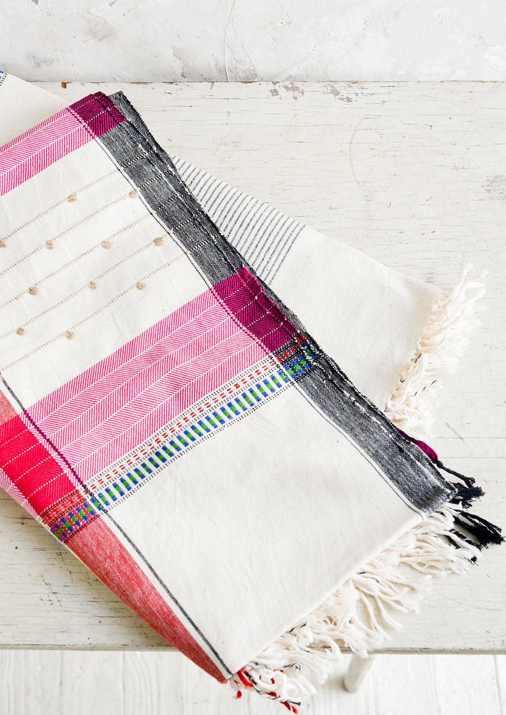 1: A woven cotton throw in a mix of colors and stitches.