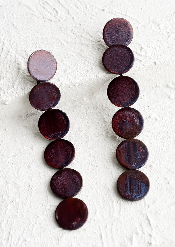 A pair of earrings made of six consecutive purple enamel discs.