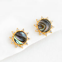 Abalone: A pair of gold stud earrings in the shape of a sun with shell inlay center and crystal "sunray" border.