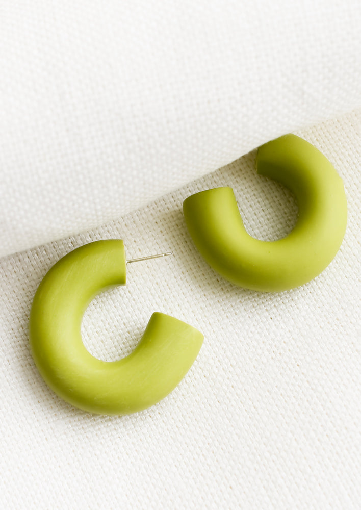 A pair of polymer clay hoop earrings in green apple.