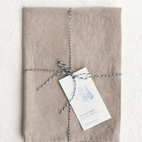 Antique Mauve: A folded faded pale mauve linen tea towel tied in baker's twine with a decorative hangtag