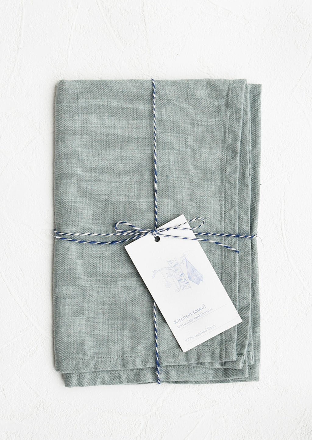 Lake Blue: A folded faded pale blue linen tea towel tied in baker's twine with a decorative hangtag