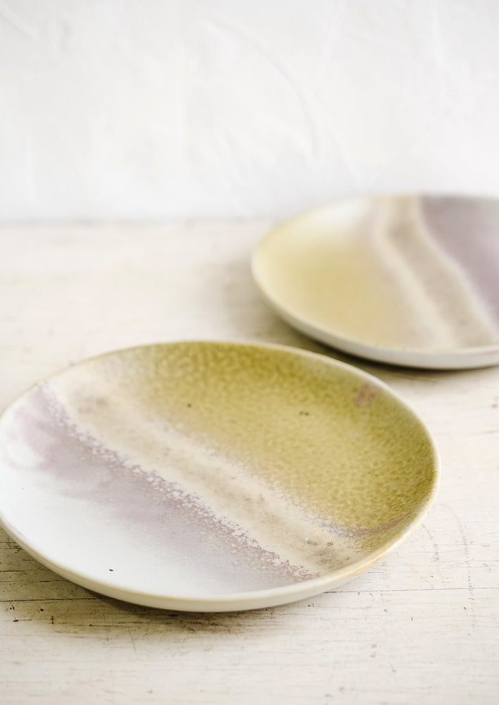 Two reactive glazed side plates sitting on a tabletop.