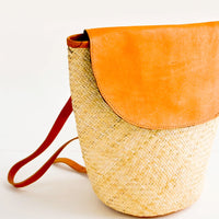 1: Woven straw backpack with leather trim and curved front flap